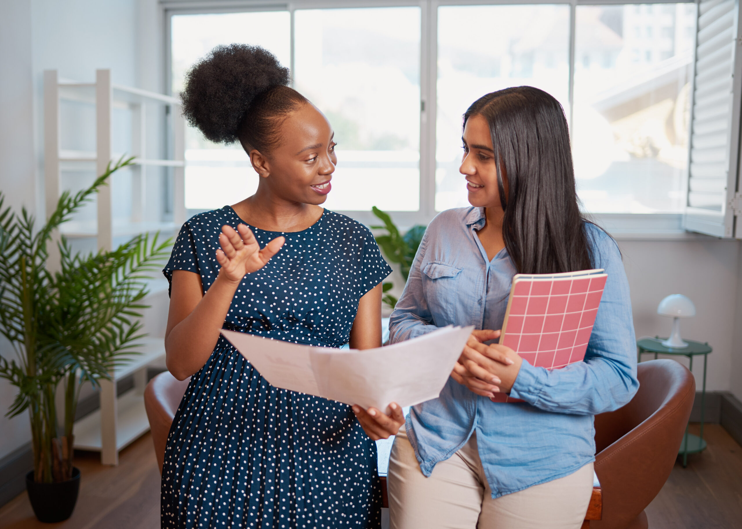 Two women discuss work solutions in boardroom office, mentorship learning hands